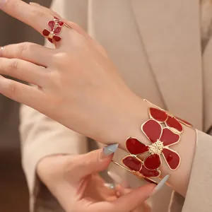 Detailopname van een elegante rode emaille bloem sieradenset met ring en armband