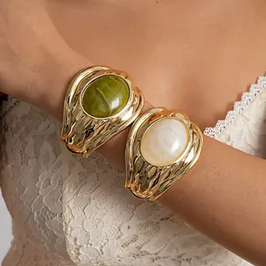 Bracciali rigidi in metallo plissettato oro con pietre ovali in resina marmorizzata