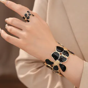 Elegante sieradenset met zwarte emaille bloemen ring en armband met rimpeltextuur details