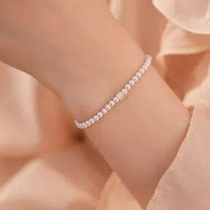 Close-up van een elegante parelarmband met zirkonia op de pols