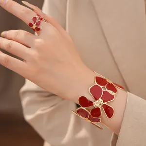 Gedetailleerde weergave van een elegante rode emaille bloem armband en bijpassende ring