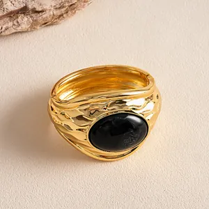 Bracciale rigido vintage in metallo dorato martellato con pietra ovale in resina nera venata.