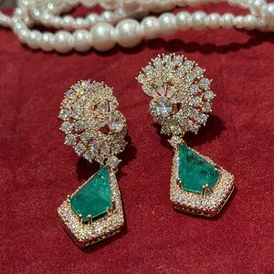 Détail des pierres vertes en forme de cerf-volant et des grappes de zircons sur boucles d'oreilles.