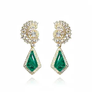 Élégantes boucles d'oreilles dorées 18 carats avec tourbillon en zircone et goutte verte
