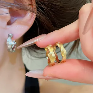 Detailaufnahme der strukturierten, gedrehten Creolen aus Metall in Gold und Silber
