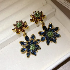 Nahaufnahme von Vintage-Blumenohrringen mit blauen und grünen Kristallen im Palaststil.