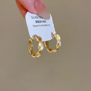 Detailansicht goldener gedrehter Creolen mit Struktur und 925er Silber Preisetikett.