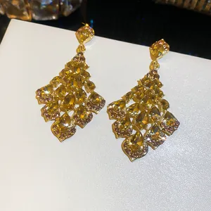 Nahaufnahme eleganter goldener Palast-Ohrhänger mit gelben Tropfenkristallen.