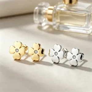 Gros plan sur les boucles d'oreilles trèfle à quatre feuilles or et argent serties
