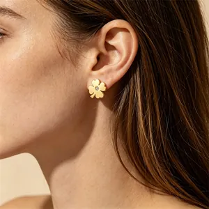 Vue détaillée d'une boucle d'oreille trèfle à quatre feuilles dorée avec cristal sur l'oreille
