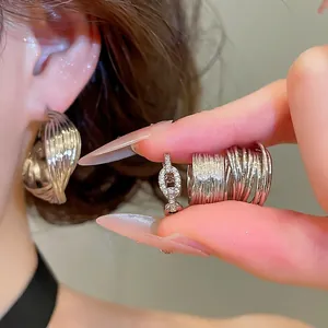 Elegant silver twisted C-shaped hoop earrings and textured rings set for stylish women