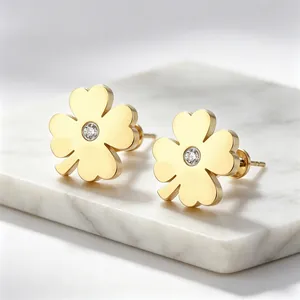 Gros plan de boucles d'oreilles trèfle à quatre feuilles dorées avec cristal