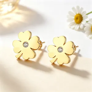 Détail de boucles d'oreilles trèfle à quatre feuilles en acier titane doré et cristal