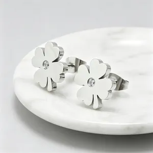 Vue détaillée des boucles d'oreilles trèfle en acier titane poli avec incrustation