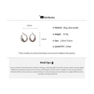 Vue détaillée des boucles d'oreilles créoles torsadées argentées en forme de C, taille 2,8 cm.