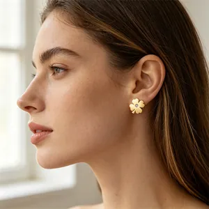 Vue détaillée des boucles d'oreilles trèfle à quatre feuilles en acier doré et strass