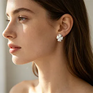 Détail d'une boucle d'oreille trèfle à quatre feuilles en acier titane sur un mannequin