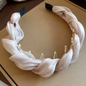 Gros plan d'un serre-tête en tissu rose torsadé avec des dents intérieures en plastique