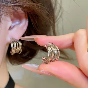 Vue détaillée de la texture torsadée des boucles d'oreilles créoles argentées en C