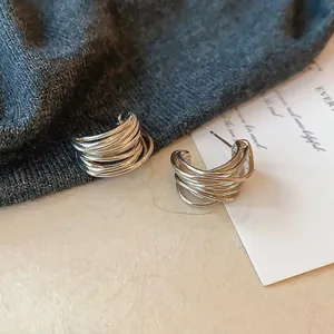 Gros plan sur des boucles d'oreilles créoles argentées à plusieurs épaisseurs