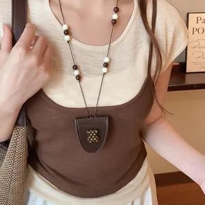 Gedetailleerd zicht op een retro lederen hanger ketting met een schattig beer accent op model