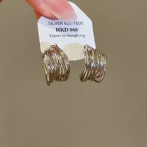 Gros plan détaillé de boucles d'oreilles argentées en forme de C torsadé sur carte