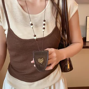Close-up van vintage bruin lederen hart brillenclip ketting met kralen details