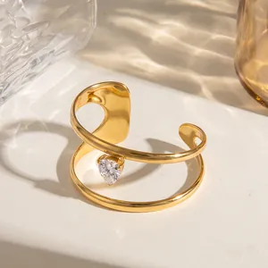 Detail van geometrische roestvrijstalen armband met hart-zirkonia en 18k vergulde afwerking