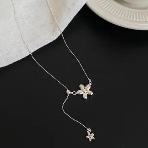 Detailed view of a silver flower pendant necklace with a delicate Y-shaped chain design.