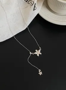 Detail view of a silver flower pendant necklace with delicate bead chain