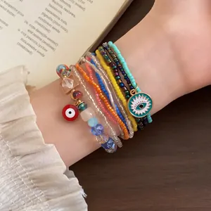 Nahaufnahme von buntem Boho-Perlenarmband-Set mit roten und blauen Evil-Eye-Anhängern
