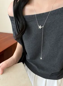 Detailed view of silver flower lariat necklace pendant worn by model for elegant styling