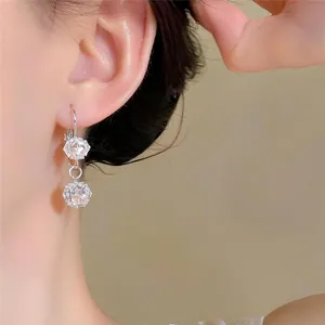 Detailed macro view of elegant French-style silver earrings with round zircon pendants