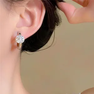 Detail close-up of elegant French style round zircon hoop earrings worn on a model's ear