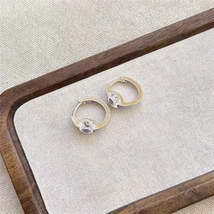 Macro view of elegant silver-toned hoop earrings with a sparkling cubic zircon stone