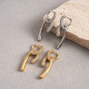 Détail de boucles d'oreilles nouées plaquées or 18k avec micro-zircons