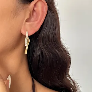 Gros plan d'une boucle d'oreille nœud en or 18 carats avec des pierres en zircone.
