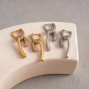 Vue détaillée de boucles d'oreilles nœud plaquées or et argent avec zircons cubiques.