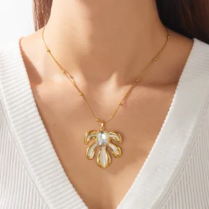 Vue détaillée d'un élégant collier en feuille plaqué or avec cristal sur un mannequin.
