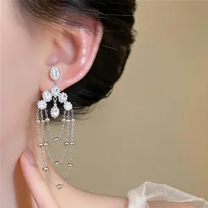 Elegante silberfarbene Quastenohrringe mit ovalem Zirkonia am Modell