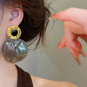 Macro view showing close-up detail of vintage geometric earrings with hammered gold finish
