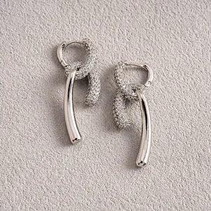 Détail macro de boucles d'oreilles nouées plaquées or 18 carats avec pavé de zircons