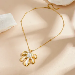 Vue détaillée du pendentif feuille plaqué or avec émail blanc et cristal étincelant