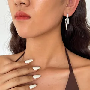 Vue détaillée de boucles d'oreilles nœuds argentées avec zircons sur un mannequin