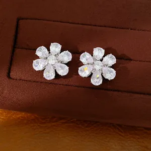 Makroansicht funkelnder Zirkonia Blumen-Ohrstecker in einer luxuriösen braunen Schmuckbox