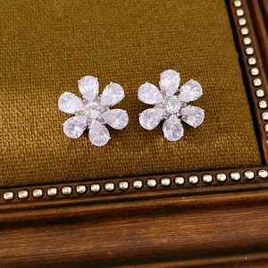 Detaillierte Nahaufnahme von funkelnden Blumen-Zirkonia-Ohrringen auf Vintage-Hintergrund
