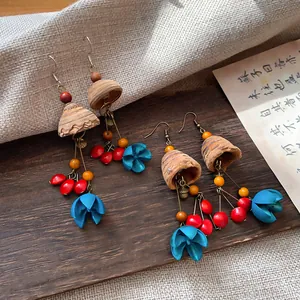 Detailed view of vintage ethnic wooden earrings with colorful tassel and blue flower accents.
