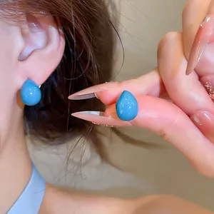 Detaillierte Makroansicht eleganter blauer Emaille-Tropfenohrstecker für minimalen Stil