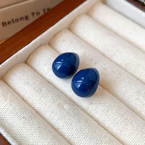 Nahaufnahme eleganter marineblauer Tropfenohrringe in Schmuckschatulle