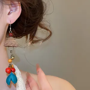 Detail view of vintage ethnic wooden tassel earring with colorful botanical beads